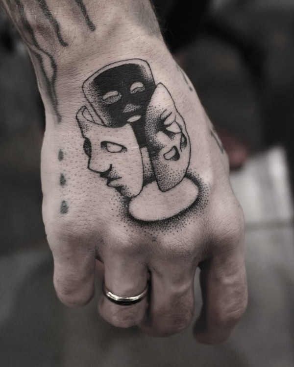 Maschere del teatro tatuate a puntinato sulla mano